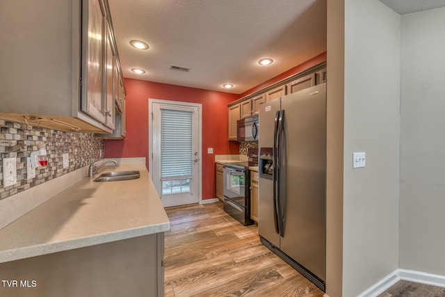 603 Stratford Ct Unit 603, Gray, TN 37615 - kitchen featuring black appliances, light countertops, light wood-style floors, tasteful backsplash, and a textured ceiling