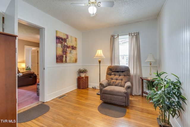 1634 Highland St, Kingsport, TN 37664 - sitting room featuring light wood-style floors, a textured ceiling, a wainscoted wall, and ceiling fan