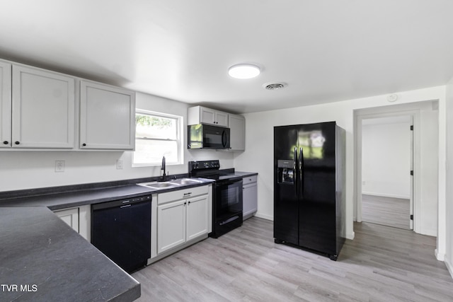 265 Hightop Rd, Midway, TN 37809 - kitchen with black appliances, dark countertops, and light wood-type flooring