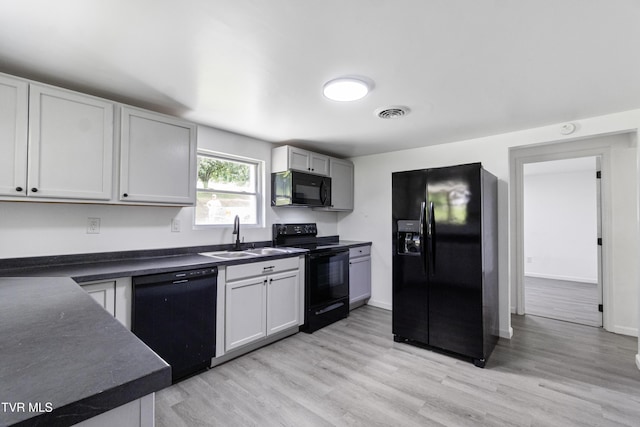 265 Hightop Rd, Midway, TN 37809 - kitchen featuring black appliances, dark countertops, and light wood-style floors