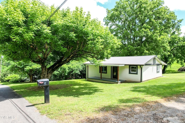 265 Hightop Rd, Midway, TN 37809 - ranch-style house featuring a porch, a front lawn, a metal roof, stucco siding, and view of wooded area