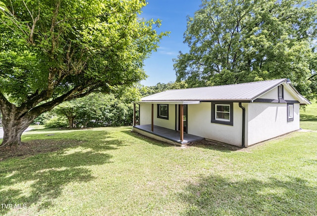 265 Hightop Rd, Midway, TN 37809 - view of front of house featuring stucco siding, a front yard, and a metal roof