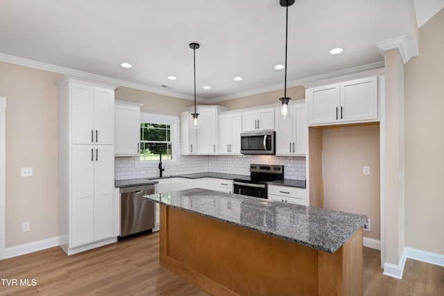 1308 Walnut Grove Rd, Jonesborough, TN 37659 - kitchen featuring appliances with stainless steel finishes, tasteful backsplash, a kitchen island, light wood finished floors, and white cabinetry