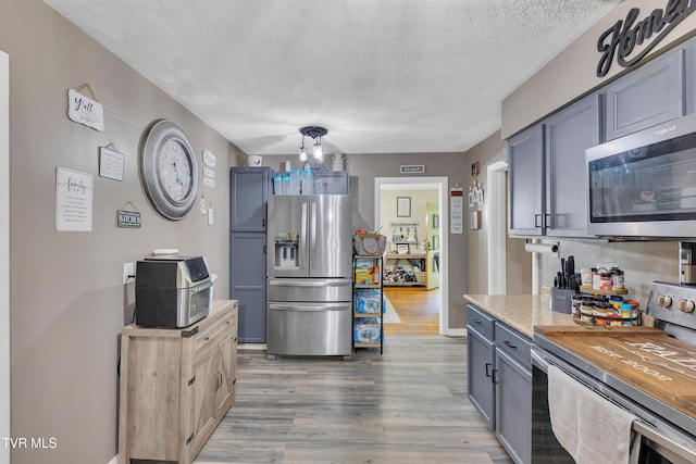 206 Cloverdale Pl, Bristol, TN 37620 - kitchen featuring stainless steel appliances, wood finished floors, light countertops, a chandelier, and a textured ceiling