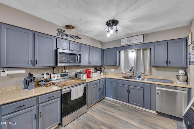 206 Cloverdale Pl, Bristol, TN 37620 - kitchen featuring appliances with stainless steel finishes, a textured ceiling, light wood-type flooring, and light countertops