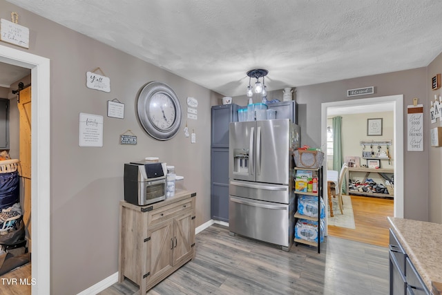 206 Cloverdale Pl, Bristol, TN 37620 - kitchen featuring stainless steel refrigerator with ice dispenser, light wood-type flooring, light countertops, a textured ceiling, and a chandelier