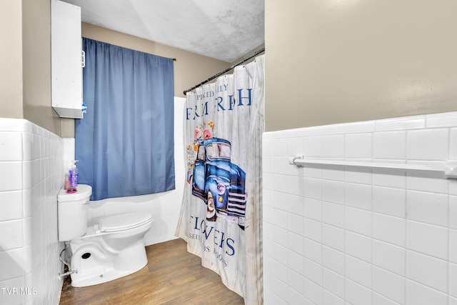 206 Cloverdale Pl, Bristol, TN 37620 - bathroom with wood finished floors, tile walls, curtained shower, a wainscoted wall, and a textured ceiling