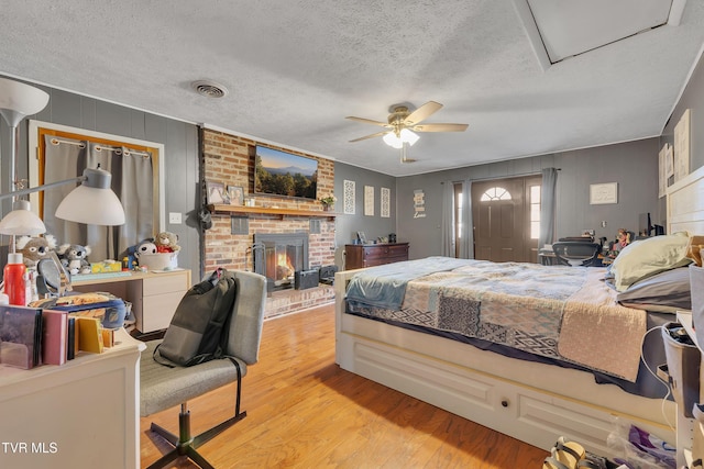 206 Cloverdale Pl, Bristol, TN 37620 - bedroom with a fireplace, light wood-type flooring, a textured ceiling, and ceiling fan