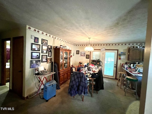3911 Tate Springs Rd, Big Stone Gap, VA 24219 - dining area with dark colored carpet, a textured ceiling, and a chandelier