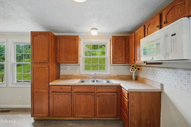 271 Anderson St, Pennington Gap, VA 24277 - kitchen featuring white microwave, plenty of natural light, light countertops, a textured ceiling, and brown cabinets