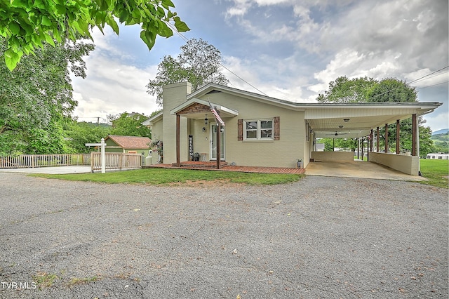 53 Grove Ave, Lebanon, VA 24266 - view of front of home featuring driveway, a chimney, a carport, and brick siding