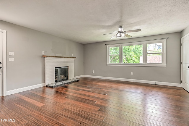 53 Grove Ave, Lebanon, VA 24266 - unfurnished living room with ceiling fan, a brick fireplace, wood finished floors, and a textured ceiling