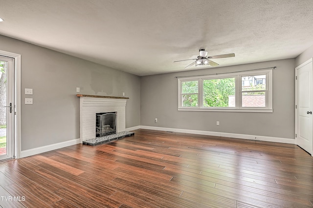 53 Grove Ave, Lebanon, VA 24266 - unfurnished living room with a ceiling fan, a brick fireplace, and wood finished floors