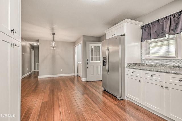 53 Grove Ave, Lebanon, VA 24266 - kitchen featuring stainless steel fridge, white cabinets, light wood-type flooring, light stone counters, and pendant lighting