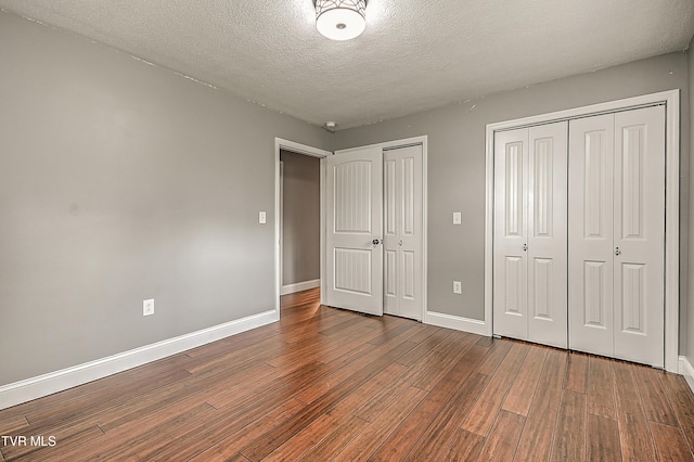 53 Grove Ave, Lebanon, VA 24266 - unfurnished bedroom with wood finished floors, two closets, and a textured ceiling