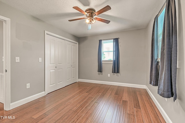 53 Grove Ave, Lebanon, VA 24266 - unfurnished bedroom featuring wood-type flooring, a closet, a textured ceiling, and ceiling fan