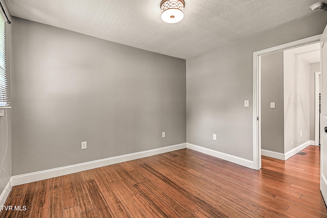 53 Grove Ave, Lebanon, VA 24266 - spare room with a smoke detector, wood finished floors, a textured ceiling, and healthy amount of natural light