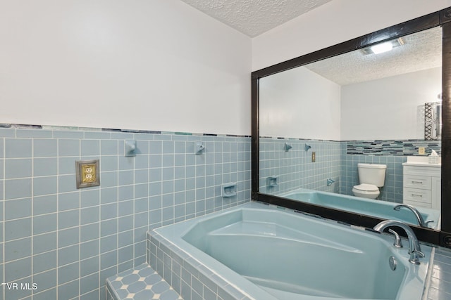 18134 Cleveland Rd, Abingdon, VA 24211 - bathroom featuring a textured ceiling, tile walls, a garden tub, vanity, and wainscoting