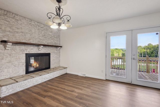 18134 Cleveland Rd, Abingdon, VA 24211 - unfurnished living room featuring wood finished floors, french doors, a chandelier, and a large fireplace