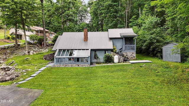 8445 Pendleton Rd, Wise, VA 24293 - view of front of home with a storage shed, a metal roof, a front yard, and a chimney