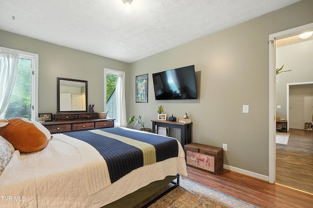 8445 Pendleton Rd, Wise, VA 24293 - bedroom featuring wood finished floors, multiple windows, and a textured ceiling