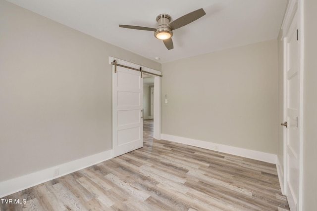 3528 Crestwood Dr, Kingsport, TN 37664 - unfurnished bedroom with a barn door, light wood-type flooring, and a ceiling fan