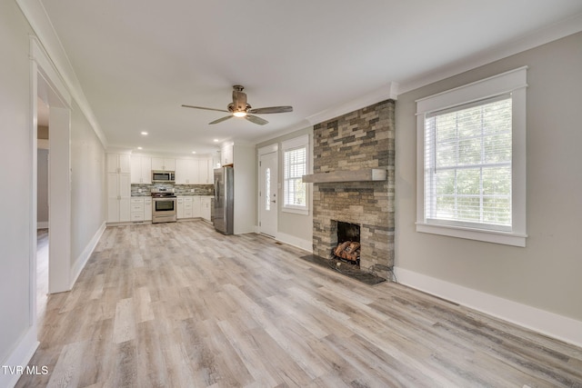 3528 Crestwood Dr, Kingsport, TN 37664 - unfurnished living room with a ceiling fan, a stone fireplace, light wood-style floors, ornamental molding, and recessed lighting