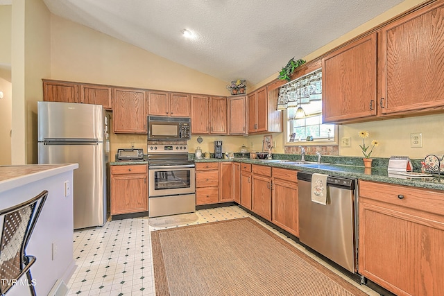 103 Jenny Ln, Jonesborough, TN 37659 - kitchen featuring stainless steel appliances, vaulted ceiling, light flooring, dark countertops, and brown cabinets