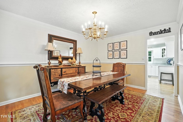 209 Timberland Cir, Kingsport, TN 37664 - dining room with a chandelier, light wood-style floors, a textured ceiling, and crown molding