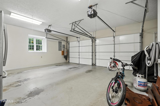 209 Timberland Cir, Kingsport, TN 37664 - garage featuring electric panel, a garage door opener, and freestanding refrigerator