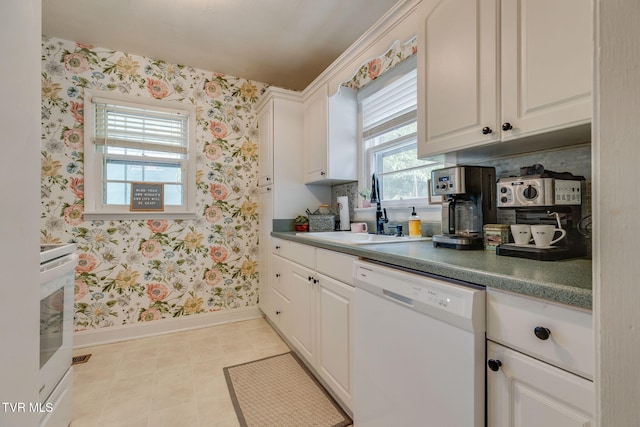49 24th St, Bristol, TN 37620 - kitchen with dishwasher, wallpapered walls, range, white cabinets, and dark countertops