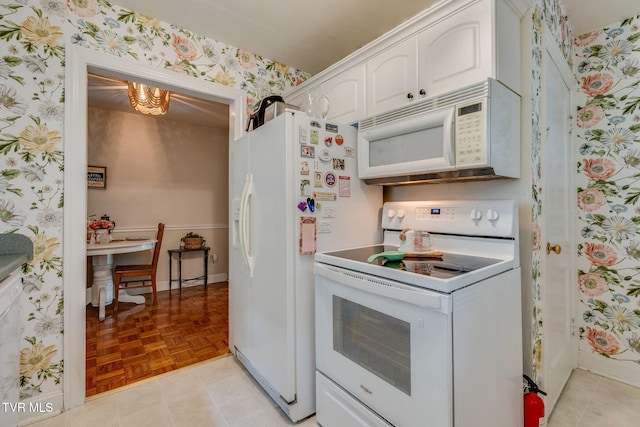 49 24th St, Bristol, TN 37620 - kitchen with white appliances, wallpapered walls, white cabinetry, and a chandelier