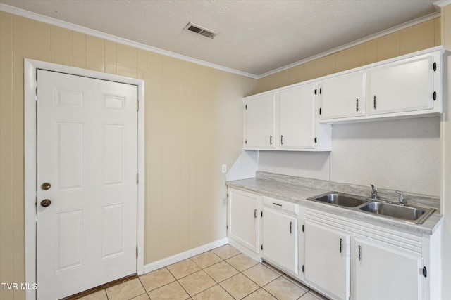 1449 E Sevier Ave, Kingsport, TN 37664 - kitchen with ornamental molding, white cabinets, light countertops, light tile patterned floors, and a textured ceiling