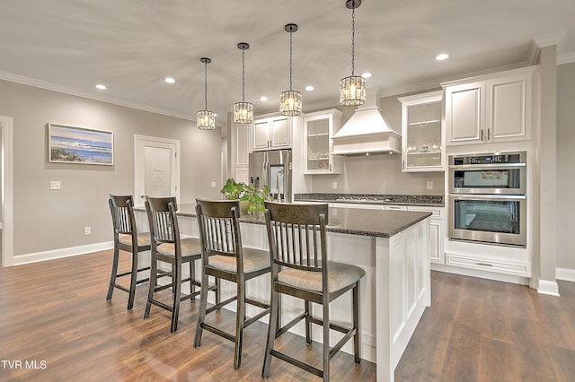 20385 Yeary Trl, Abingdon, VA 24211 - kitchen with appliances with stainless steel finishes, custom exhaust hood, a center island, a breakfast bar, and ornamental molding