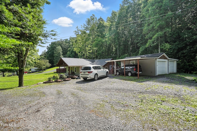 169 Mays Rd, Elizabethton, TN 37643 - view of front of home with a garage, a front yard, a metal roof, an outdoor structure, and a forest view