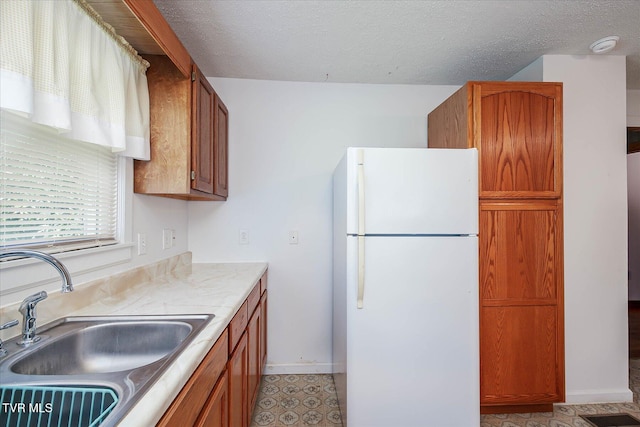 227 Jonesboro Dr, Bluff City, TN 37618 - kitchen featuring freestanding refrigerator, brown cabinets, light countertops, and a textured ceiling