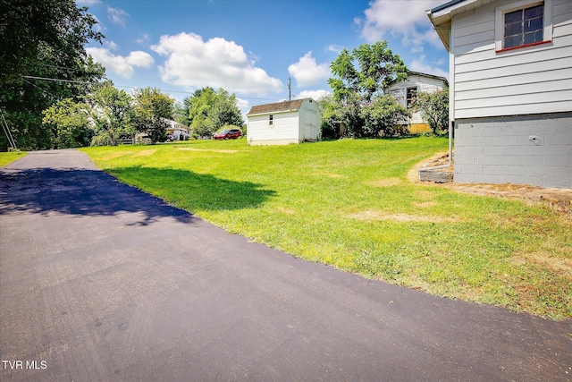 227 Jonesboro Dr, Bluff City, TN 37618 - view of grassy yard with a storage unit and asphalt driveway