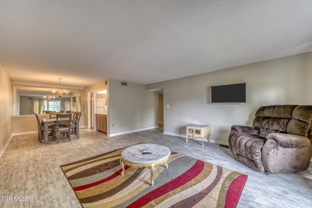 202 University Pkwy Unit 4E, Johnson City, TN 37604 - living room featuring a textured ceiling, a chandelier, and wood finished floors