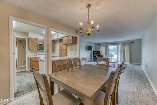 202 University Pkwy Unit 4E, Johnson City, TN 37604 - dining room with a chandelier, light wood-style floors, and a textured ceiling