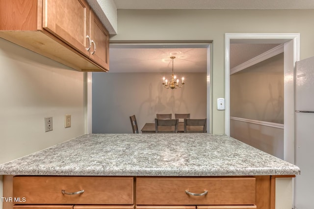 202 University Pkwy Unit 4E, Johnson City, TN 37604 - kitchen with brown cabinets, a chandelier, and freestanding refrigerator