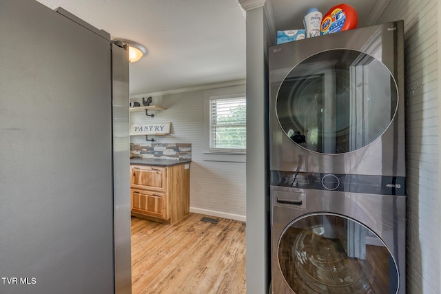 406 Mclaney Rd, Watauga, TN 37694 - laundry area with estacked washer and dryer, ornamental molding, and light wood finished floors