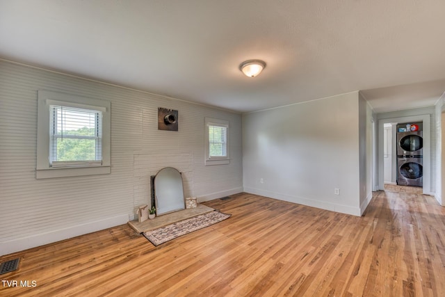 406 Mclaney Rd, Watauga, TN 37694 - unfurnished living room with estacked washer and dryer, plenty of natural light, light wood finished floors, and ornamental molding