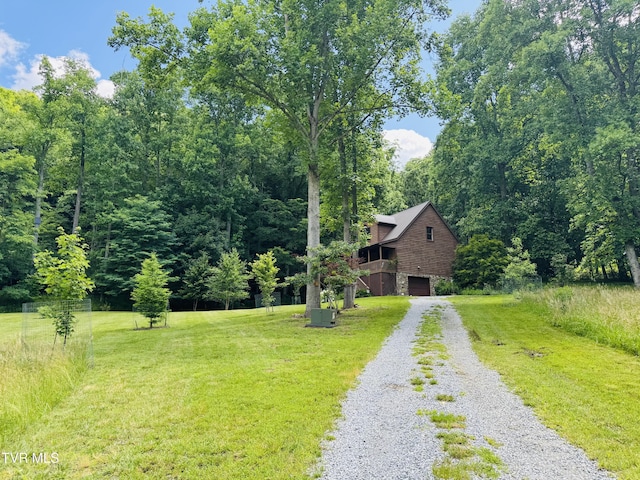 103 Meadow Springs Ct, Flag Pond, TN 37657 - view of front of house with an attached garage, stone siding, gravel driveway, a front yard, and a forest view