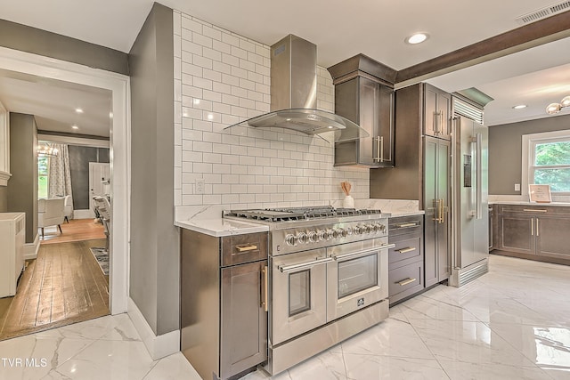 2061 King College Rd, Bristol, TN 37620 - kitchen featuring high quality appliances, wall chimney exhaust hood, light marble finish flooring, dark brown cabinets, and recessed lighting