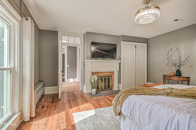 2061 King College Rd, Bristol, TN 37620 - bedroom with light wood-style flooring, a chandelier, a fireplace with flush hearth, and a closet