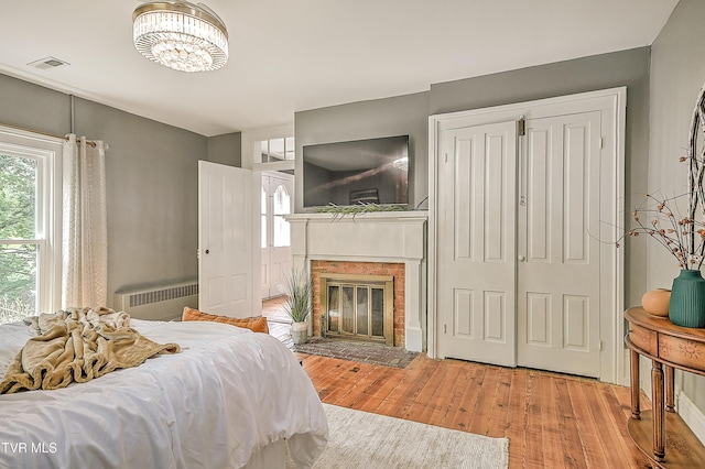 2061 King College Rd, Bristol, TN 37620 - bedroom with radiator, wood finished floors, multiple windows, and a brick fireplace