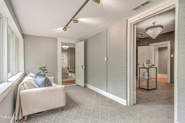 2061 King College Rd, Bristol, TN 37620 - corridor featuring brick wall, carpet floors, track lighting, and a chandelier