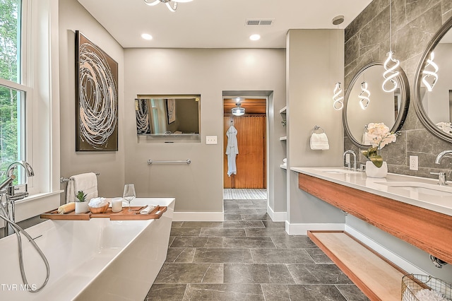 2061 King College Rd, Bristol, TN 37620 - bathroom featuring a freestanding bath, double vanity, and tasteful backsplash