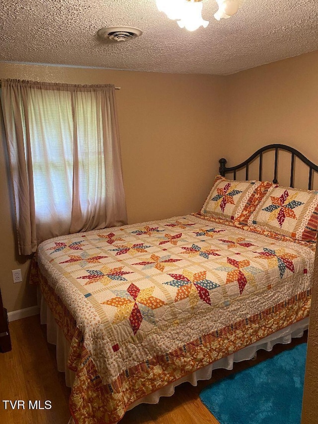880 E Gilley Ave, Big Stone Gap, VA 24219 - bedroom featuring wood finished floors and a textured ceiling