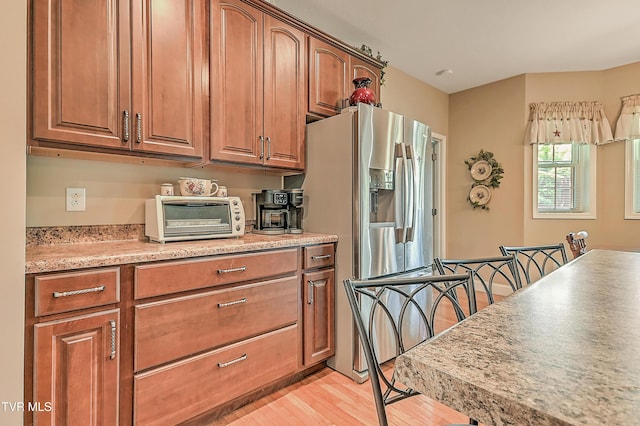 5000 Aberlea Pl, Piney Flats, TN 37686 - kitchen featuring light wood-style flooring, light countertops, brown cabinetry, and stainless steel fridge
